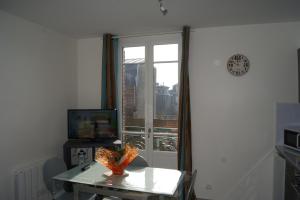 a living room with a table and a window at Simple Asile in Mers-les-Bains