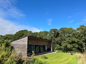 a small house in a field with trees at Orchard Hideaway in Kelso