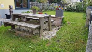 a wooden picnic table sitting in the grass at Moderne, Niveauvoll Eingerichtete Ferienwohnung in Eibenstock