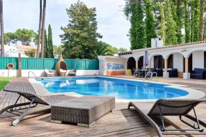 una piscina con due sedie e una terrazza in legno di Elegant Villa in Corroios with Private Pool a Corroios