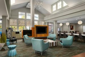 a lobby with blue chairs and a dining room at Residence Inn Florence in Florence