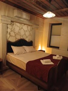 a bedroom with a large bed with a stone wall at ELEGANT HOUSE Cappadocia in Urgup