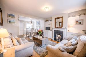 een woonkamer met twee banken en een open haard bij Shrimpers, Southwold in Southwold