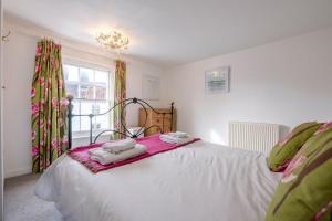 een slaapkamer met een bed met twee handdoeken erop bij Shrimpers, Southwold in Southwold