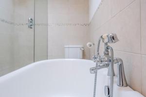 een badkamer met douche en ligbad bij Shrimpers, Southwold in Southwold +26 foto's