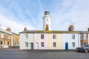 een vuurtoren staat bovenop een wit gebouw bij Shrimpers, Southwold in Southwold