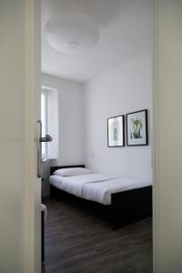 1 dormitorio con 2 camas, paredes blancas y suelo de madera. en Nenè - La Scalinata apartments, en Bellagio