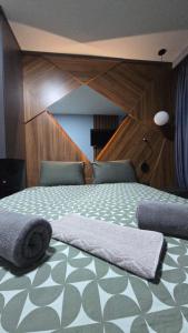 una camera con un letto e un piumone verde e bianco di The Luxe Premier Suite a Skopje Altre 3 foto