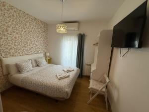 a small bedroom with a bed and a flat screen tv at Hostal Flat55Madrid in Madrid