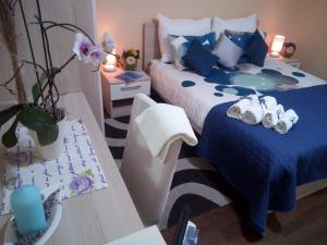 1 dormitorio con 1 cama azul y blanca y 2 mesas en Marina Guesthouse en Korčula