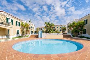 a swimming pool in the middle of a courtyard with buildings at Sunset Apartment in Porches