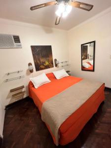 a bedroom with a large bed with an orange blanket at B&B La Mendoza in San Miguel de Tucumán