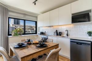 a kitchen with a wooden table with chairs and a counter at Diamond Views - Luxury Sea Point Apt with views in Cape Town