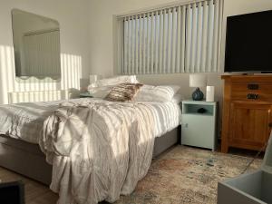 a bedroom with a bed and a flat screen tv at Fintra Bay Hideaway in Killybegs +35 photos