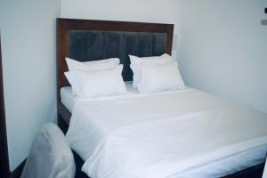 a large white bed with white sheets and pillows at Vivid Colombo in Colombo