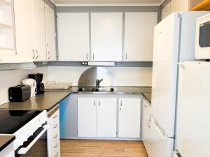 a kitchen with white cabinets and a sink at Lägenhet nära Isaberg in Nissafors +40 photos