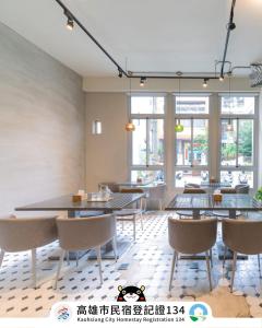 a dining room with tables and chairs and windows at Dagan B&B in Kaohsiung