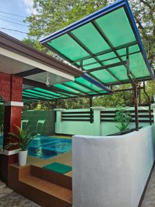 patio z basenem i zielonym baldachimem w obiekcie La-Lian Summer Resort Batangas w mieście Prenza