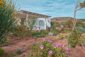 a small white house with flowers in the yard at Villa Amalia at Campos Antiparos in Andiparos