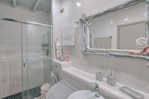 a bathroom with a sink and a shower and a mirror at Villa Amalia at Campos Antiparos in Andiparos