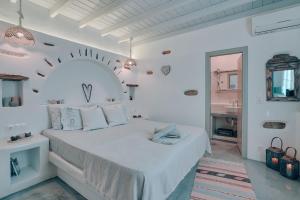 a white bedroom with a large bed in a room at Villa Amalia at Campos Antiparos in Andiparos