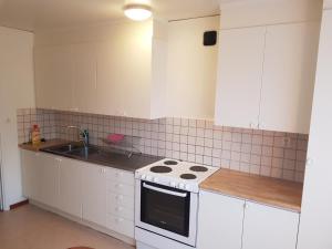 una cucina con mobili bianchi e un forno a piano cottura di Corporate apartment a Fellingsbro