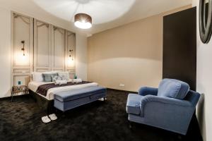 a bedroom with a bed and a blue chair at Sweet Inn - Paix in Paris