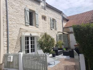 a white fence in front of a house at Maison de charme avec terrasse in Ver-sur-Mer