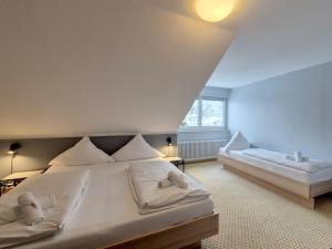 a bedroom with a large bed with white pillows at Hotel Schachener Hof in Lindau +14 photos