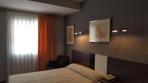 a bedroom with a bed and a chair and a window at Hotel La Bolera in Vinaròs +58 photos