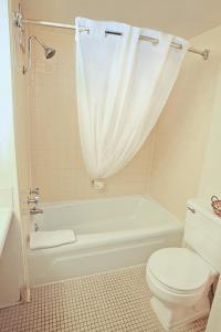 a bathroom with a toilet and a tub and a sink at National 9 Inn Showboat in Casper