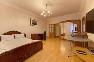 a bedroom with a bed and a desk and a table at Piterstay on Mayakovskaya in Saint Petersburg