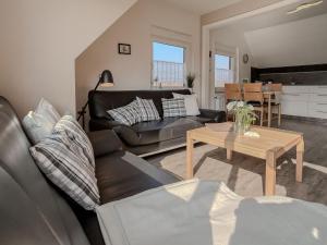 a living room with a couch and a table at FeWo Oldeoog OG - Horumersiel in Horumersiel