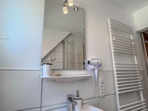 a bathroom with a mirror and a sink at FeWo Oldeoog OG - Horumersiel in Horumersiel +25 photos