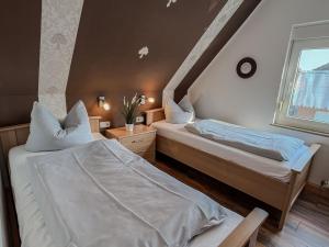 two twin beds in a room with a window at FeWo Oldeoog OG - Horumersiel in Horumersiel