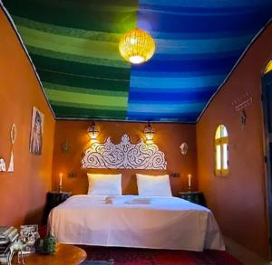 una camera con un letto e un soffitto colorato di Nomads Life Style a M'Hamid