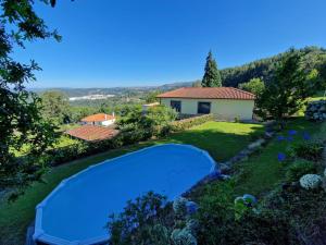 a swimming pool in the yard of a house at Casa do Cedro in Paredes de Coura