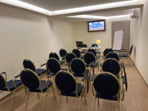 sala konferencyjna z krzesłami i ekranem projekcyjnym w obiekcie Relais Dei Mandorli w Bergamo
