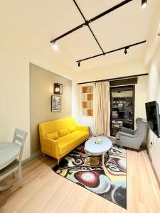 a living room with a yellow couch and a table at Elements Service Suites Time Square kl in Kuala Lumpur