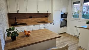 a kitchen with a counter with a bowl of oranges on it at Casa Arenal COMILLAS, grande, céntrico y tranquilo, con jardín y piscina, ideal para familias in Comillas