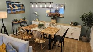 a living room with a dining room table and chairs at Casa Arenal COMILLAS, grande, céntrico y tranquilo, con jardín y piscina, ideal para familias in Comillas