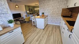 a kitchen with white cabinets and a counter top at Casa Arenal COMILLAS, grande, céntrico y tranquilo, con jardín y piscina, ideal para familias in Comillas