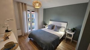 a bedroom with a bed and a chandelier at Casa Arenal COMILLAS, grande, céntrico y tranquilo, con jardín y piscina, ideal para familias in Comillas