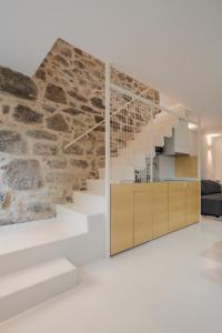 ein Wohnzimmer mit einer Treppe und einer Steinmauer in der Unterkunft Casa Dorado in Pontevedra