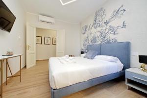 a bedroom with a large bed with a blue headboard at 4BNB - Stylish Spacious Apartment near Vatican in Rome +31 photos
