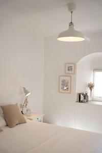a white bedroom with a bed and a desk at Casa Bekkevé - Califa Casas in Vejer de la Frontera