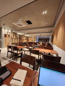 a dining room with tables and chairs and a laptop at Hotel Estilo MB - Mar del Plata in Mar del Plata