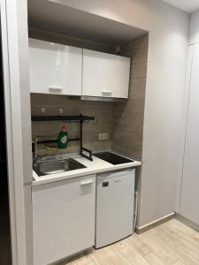 a small kitchen with white cabinets and a sink at Luxury cozy appartment in the city center in Rhodes Town