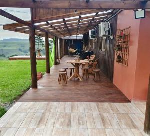a wooden deck with a table and chairs on it at Casa de campo Cantinho dos Serranos in São Joaquim
