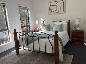 a bedroom with a bed with green pillows at The hidden retreat in Doreen